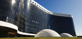 Fachada do TSE.Na parte frontal, destacam-se duas estruturas em formato de cúpula, de cor clara,...
