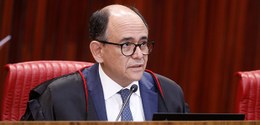 A imagem mostra o Ministro Antonio Carlos Ferreira, usa óculos, de terno e gravata azul, trajand...