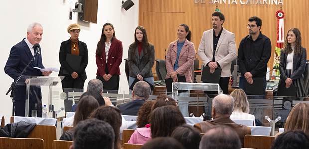 TRE-SC empossa sete novos servidores aprovados no concurso de 2024 Cerimônia de posse, com presidente do TRE-SC parabenizando os sete novos servidores. Foto Lucian...