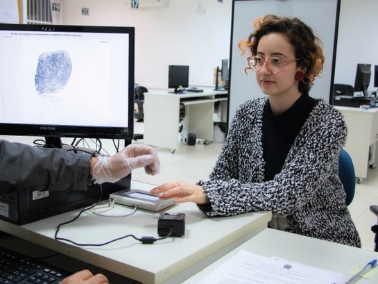 Biometria de uma eleitora sendo coletada por um servidor do Tribunal Regional Eleitoral de Santa...