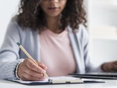 Mulher escrevendo, fazendo referência aos estudos. 