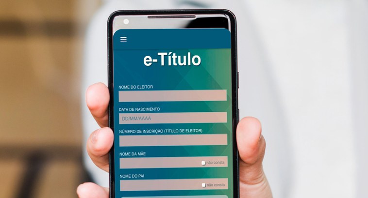 Pessoa segurando um celular com o aplicativo e-Título aberto 