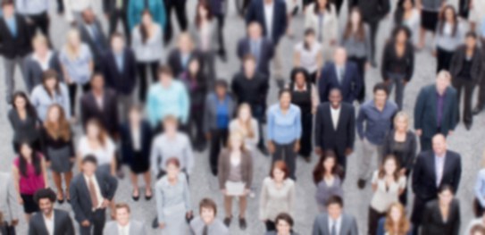 Fotografia de um grupo de pessoas olhando para cima, em direção à câmera. Elas estão sobre uma c...