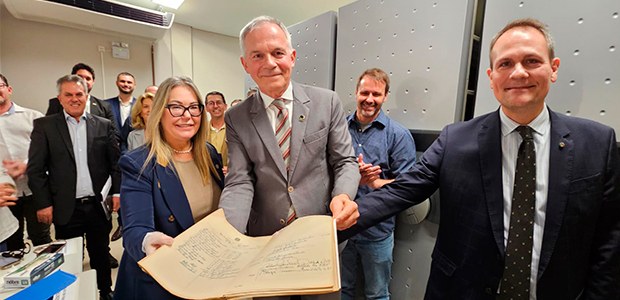 arquivo-typo-8 Presidente do TRE-SC em pé com um documento histórico aberto pousando para foto