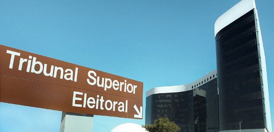 Fachada TSE - Nota de esclarecimento A imagem mostra uma placa de sinalização marrom com a inscrição “Tribunal Superior Eleitoral” e ...