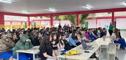 Imagem de alunos de uma escola pública assistindo uma palestra