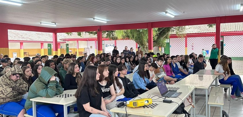 Imagem de alunos de uma escola pública assistindo uma palestra