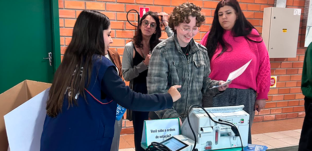 imagem de pessoas votando em urnas eletrônicas.