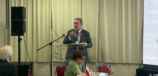 TRE-SC - CCORELB - CRESC Imagem de um homem de pele branca e cabelos curtos e grisalhos discursando para um público sentado.