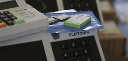 Mídias de carga ao lado de urna eletrônica