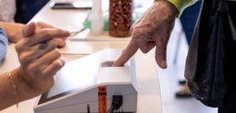 Eleitora atestando identidade no momento da votação através do reconhecimento biométrico